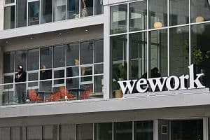 The WeWork logo is displayed outside of an office space rental location in Santa Monica, California on March 20, 2023. (Photo by Patrick T. Fallon / AFP) 