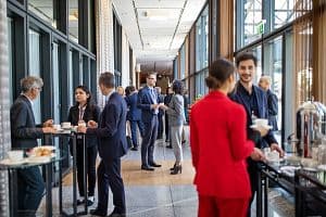 Business people having a refreshment break at conference. Corporate professionals standing in corridor and having coffee. (Getty Images)