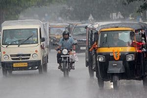Commuters and vehicles traverse a daily market area in the rain in the eastern Indian state Odisha's capital city of Bhubaneswr. (Getty Images)